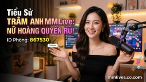 Banner hồ sơ idol Trâm Anh MMLive, giới thiệu 'Nữ hoàng quyến rũ!' với ID phòng 867530. Hình ảnh một nữ streamer trẻ mỉm cười trước thiết bị livestream, với các biểu tượng trái tim và kim cương bay lên. Bao gồm domain otxe.io.